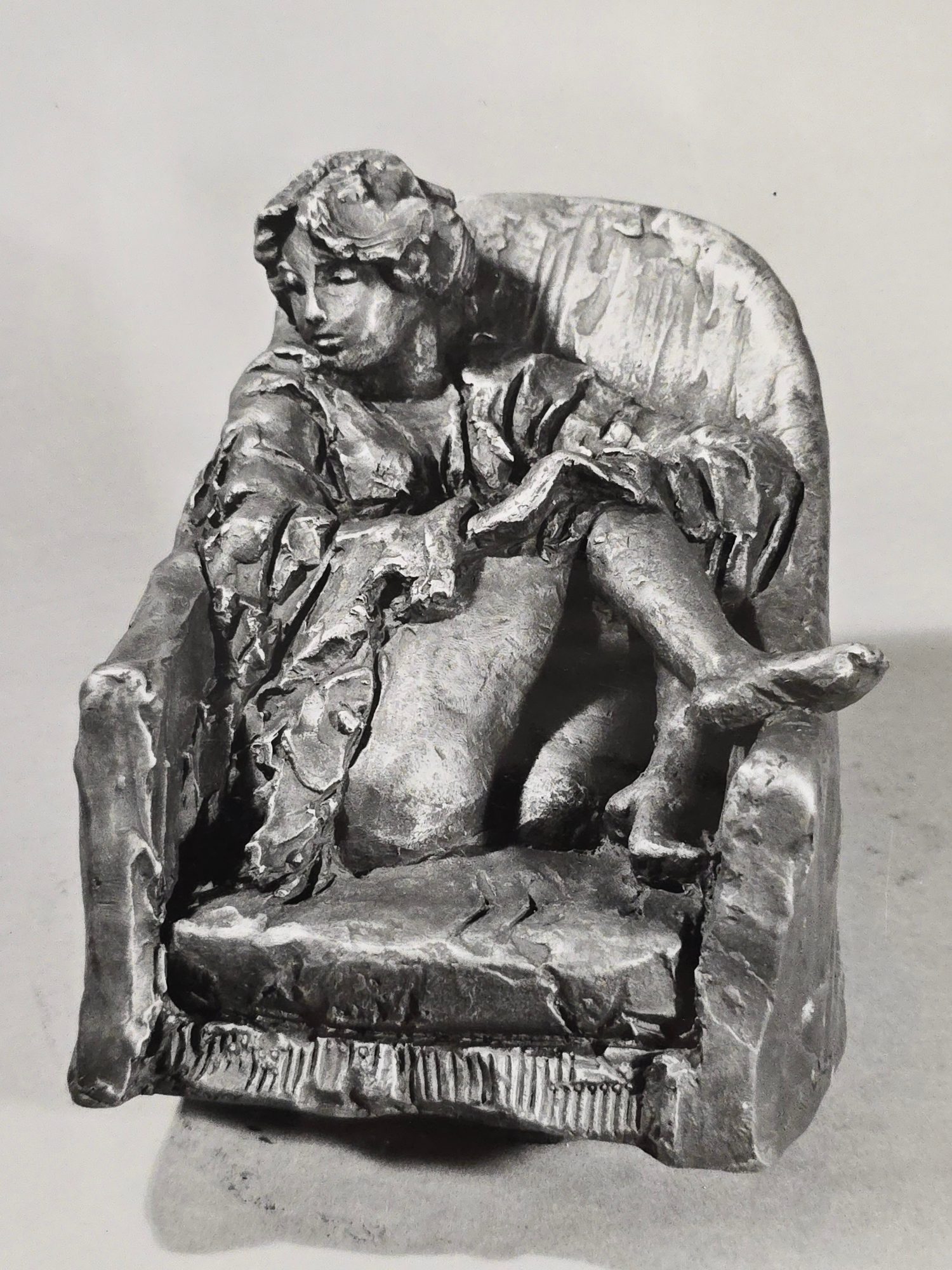 Scultura di donna su poltrona in terracotta