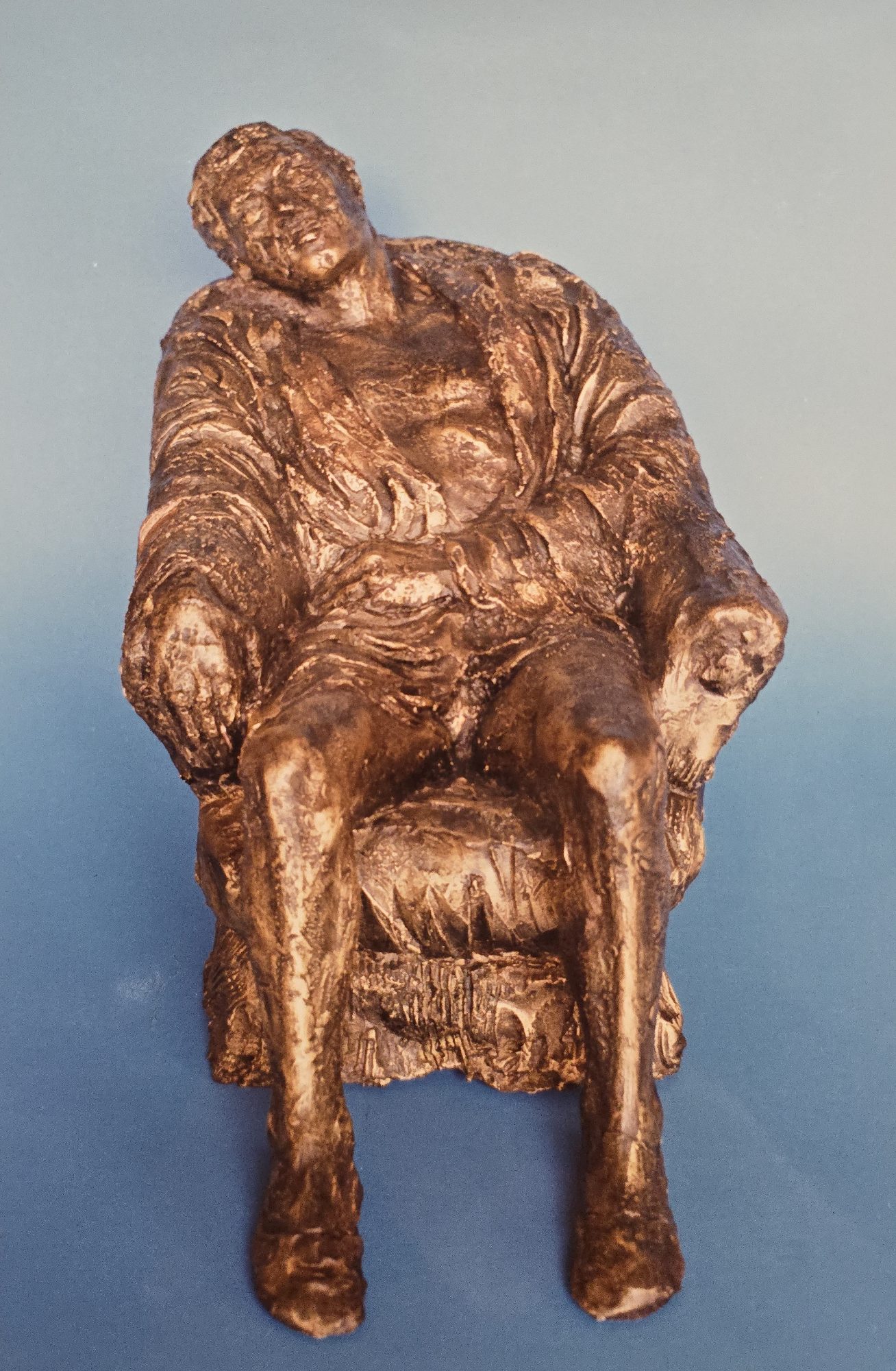 Scultura in vetroresina di uomo seduto su una poltrona di Klirò