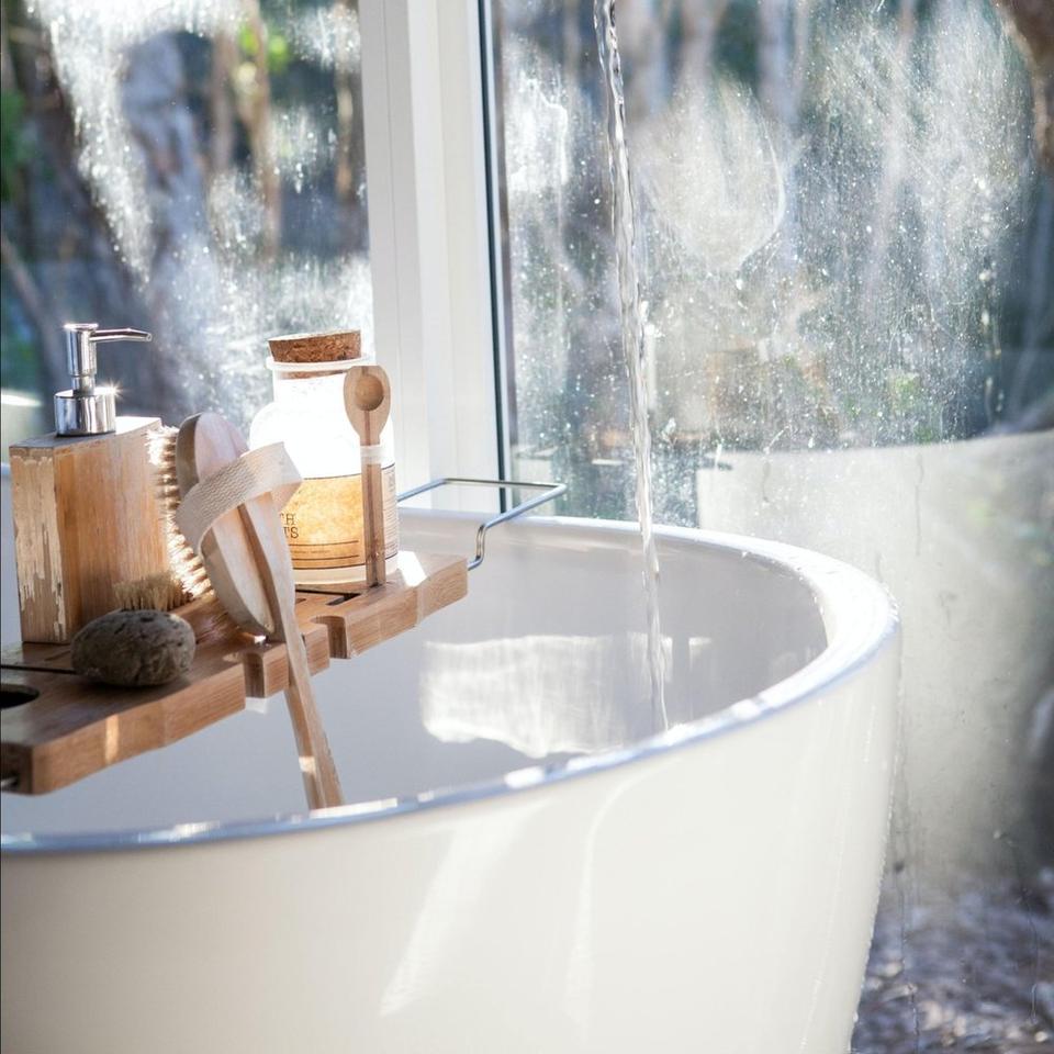 A tub, running water, and various skin products and scrubs