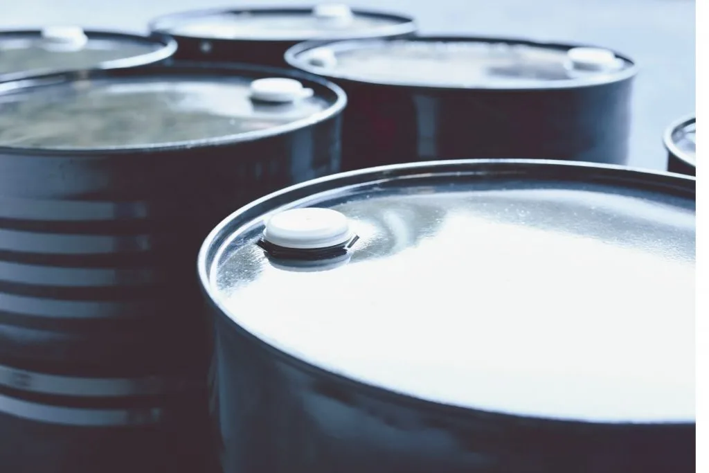 Several dark steel drums with white bungs, seen from above