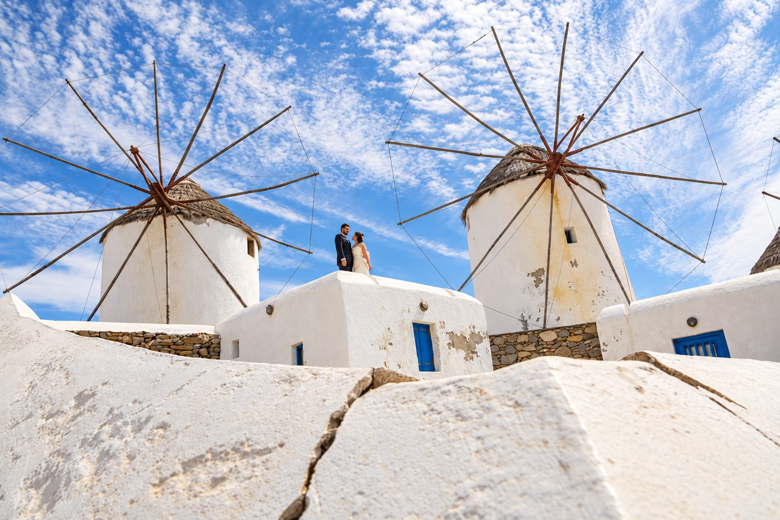 Η κεριοφωτισμένη βεράντα του Krama το βράδυ, με τραπέζια στρωμένα πάνω από τις στέγες της Μυκονιάτικης Χώρας και την πισίνα φωτισμένη δίπλα