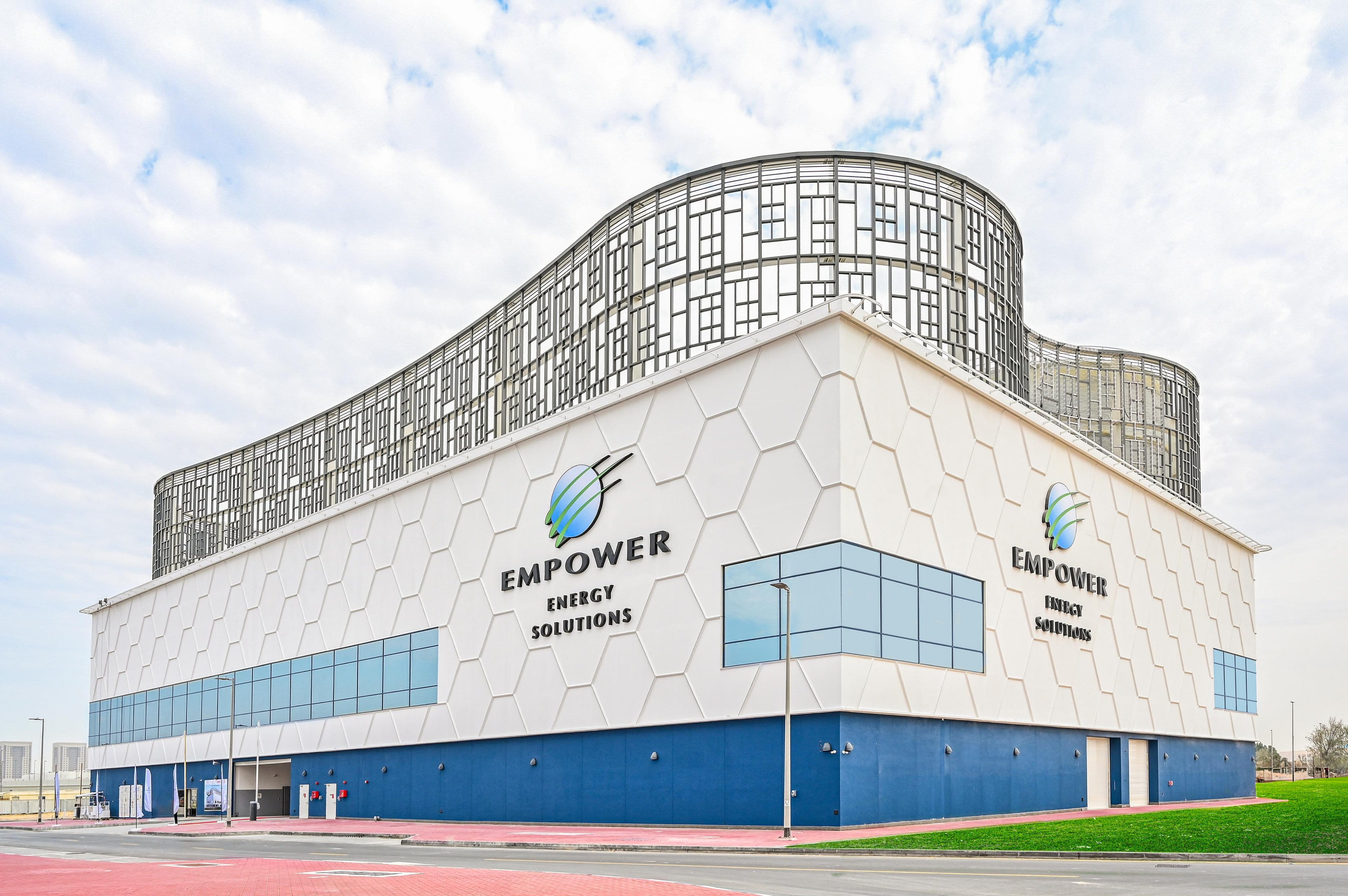 Official photograph of an Empower Energy Solutions district cooling plant in Business Bay, white honeycomb facade under a metallic screen