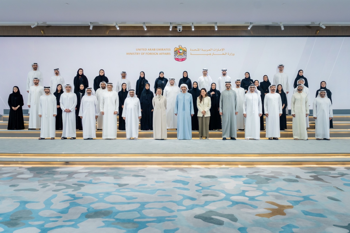 Official photograph of officials of the United Arab Emirates Ministry of Foreign Affairs posed at ministry headquarters in Abu Dhabi, UAE emblem and Ministry of Foreign Affairs backdrop in English and Arabic