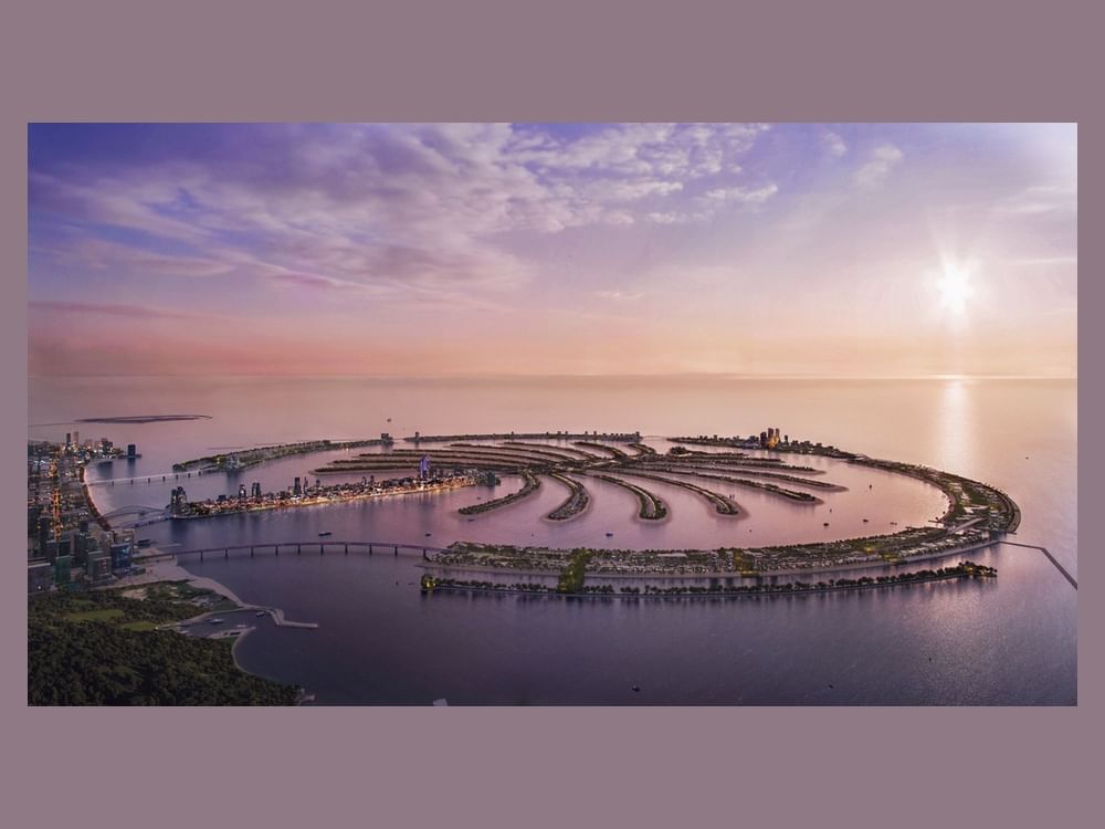 Official WAM press aerial of Palm Jebel Ali at dusk, palm-shaped islands and breakwater, Dubai skyline on the left