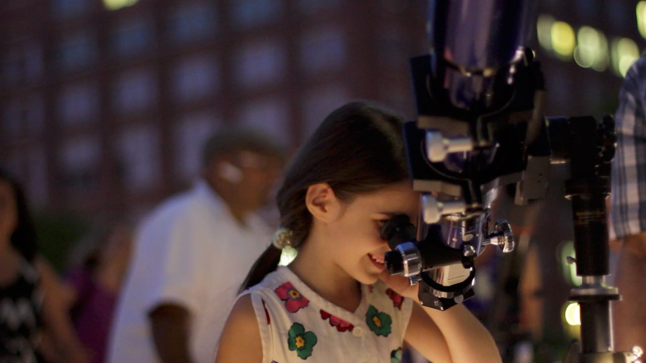 Young Girl Looks through a Telescope