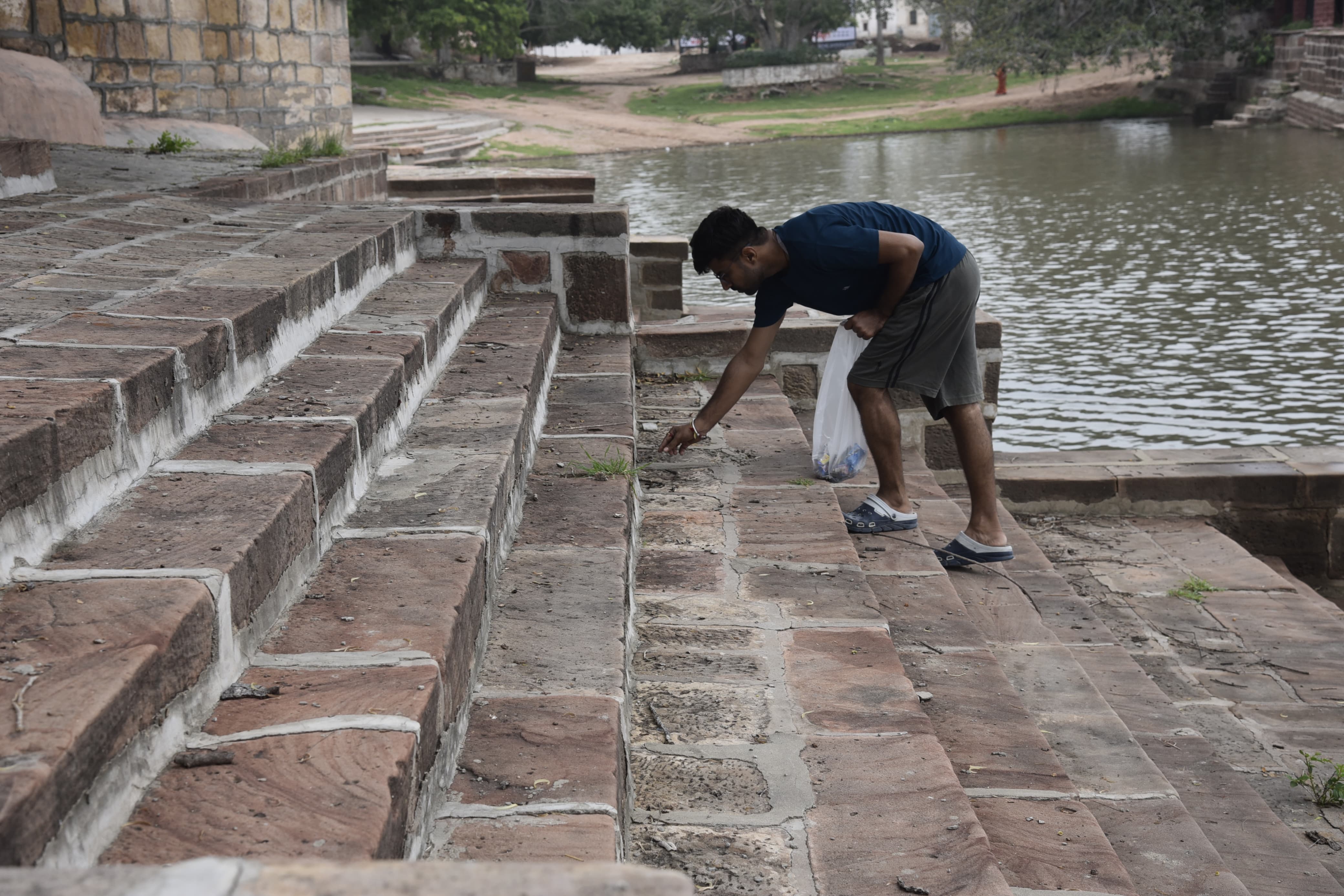 Removing plastic waste from the stairs at pond