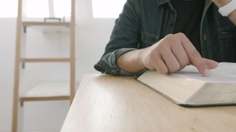 Someone reading a book while scanning pages with their finger.