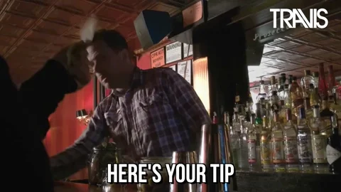 A person hands a tip to a bartender.