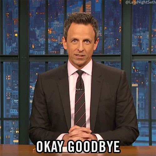 Seth Meyers sitting at talk show desk, wearing suit and tie, waving, saying, 