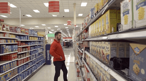 A person in a red shirt in a store nodding his head indicating YES (GIF by Trey Kennedy)