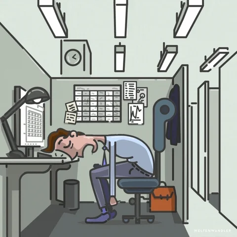 An office worker sleeps on the desk in a cubicle. The monitor outputs Z's across the screen.