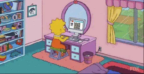 Lisa Simpson at her bedroom desk, scrolling on a computer.