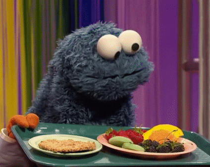 Cookie Monster deciding which plate of food to eat.