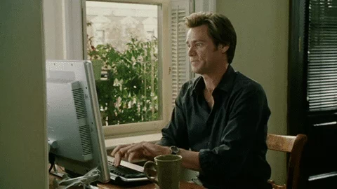 Jim Carrey types quickly on a computer.