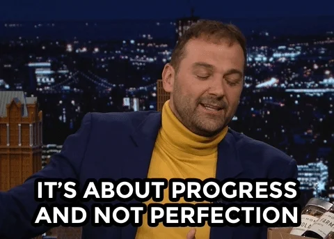 A man gestures with his hands while explaining, with text on screen that reads “It’s about progress and not perfection.”