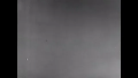 An old newsreel showing radioactive particles spreading through the atmosphere after a bomb explodes.