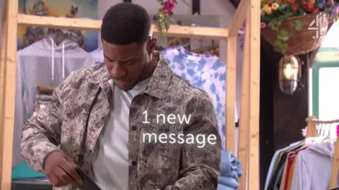 A man looking surprised as he reads an unexpected text message on his phone.