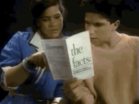 Two young people are reading a booklet titled: 