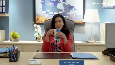 A recruiter sitting on her desk, sipping coffee and relaxing as she uses AI for recruiting.
