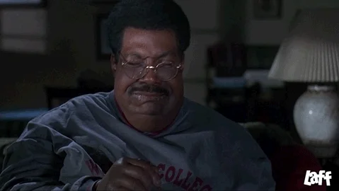 Eddie Murphy as The Nutty Professor, sitting at home crying and pouring candy into his mouth.