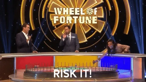 Wheel of Fortune: Someone is turning the wheel and the caption says, 'Risk it!'