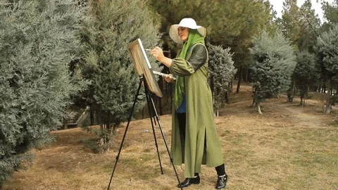 An artist painting outside. The text reads, 