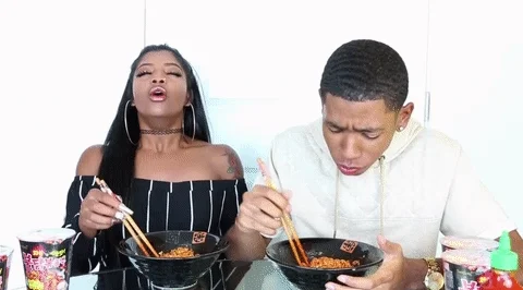 A couple eating noodles that are too spicy.