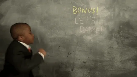 Child dancing in front of a blackboard with the words 'Bonus! Let's Dance! in the background.