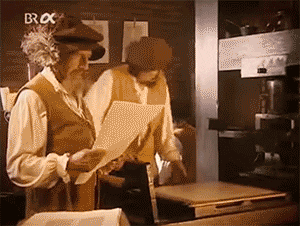 Two men from the Renaissance using the printing press in a shop