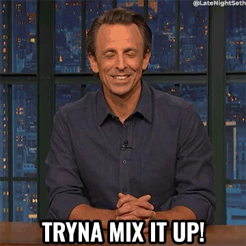 Seth Meyers in a blue collared shirt behind a news desk. He says, 