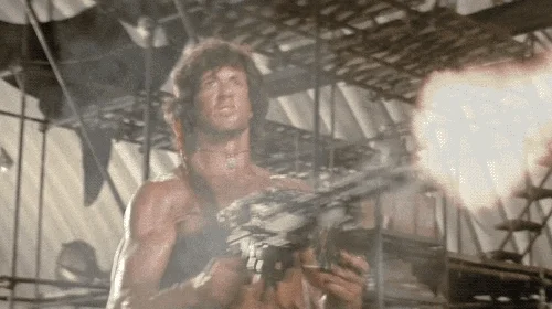 Rambo shooting a machine gun.