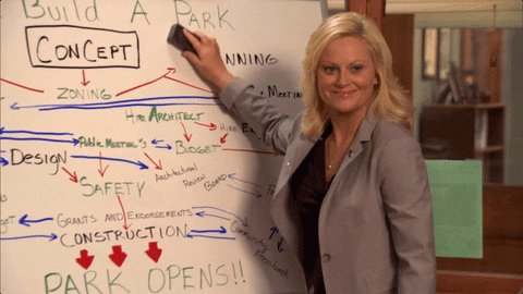Leslie at a whiteboard showing her plans for building a park