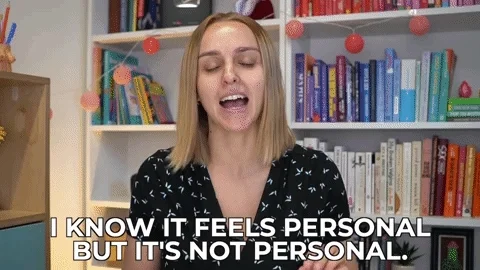 A woman in front of a bookshelf confidently stating, 'I know it feels personal but it's not personal.'