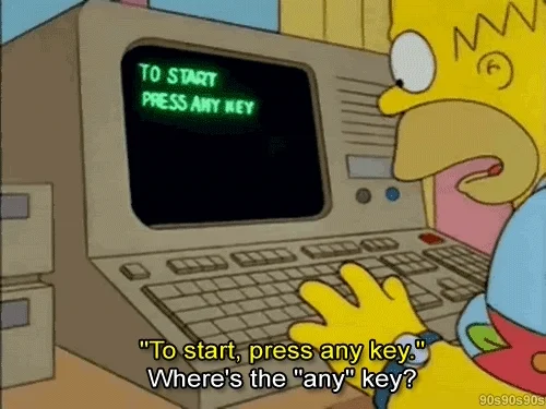 Homer Simpson at a computer, looking confused.