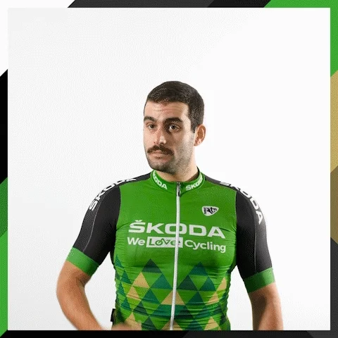 Man in a cycling outfit looking towards the distance. 