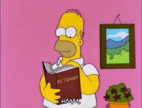 A cartooned man named Homer Simpson is thumbing through a dictionary and saying, 