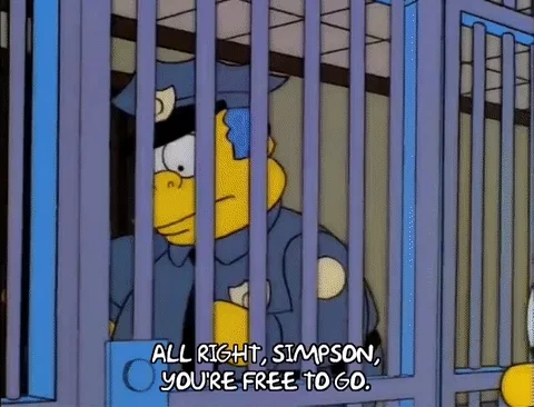 Chief Wiggum opens a cell door and tells Homer Simpson that he's free to go.