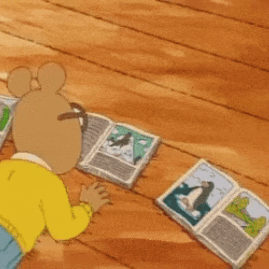 Arthur the cartoon character reading many books on the floor laid out in a circle