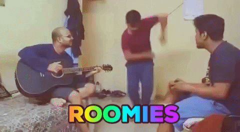 one man plays guitar, another claps his hands, while a third dances. The caption on the image says 'roomies'