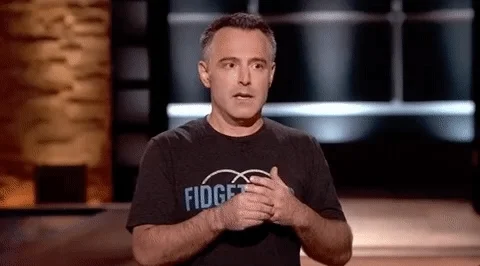 A TV host looking anxious and fidgeting with his hands. 