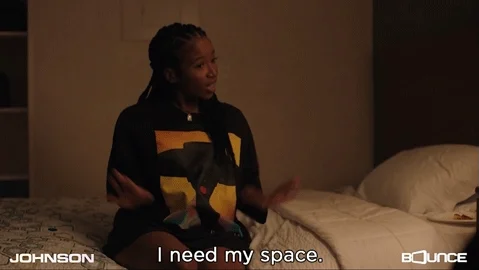 A woman sitting on a bed saying 'I need my space.'