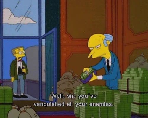 Mr Burns from The Simpsons, with stacks of money around him, trying to squeeze cash into a wallet that's already full.