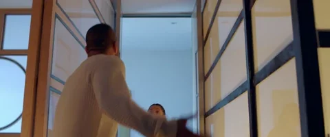 Two people arguing in a hallway. They're shouting and making large gestures with their hands.