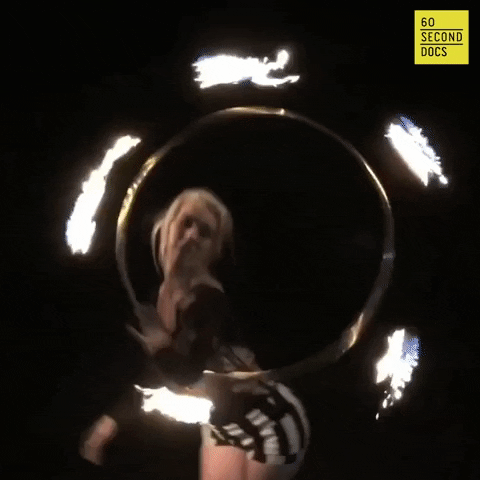 A performer dancing in a flaming hoop.