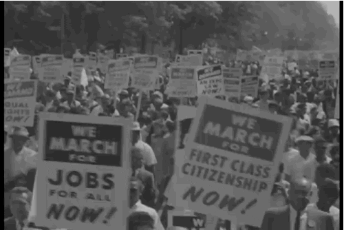Black protesters with signs that say 'We march for jobs for all now' and 'we march for first class citizenship now'