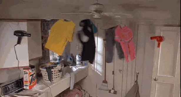 Clothes hanging off spinning ceiling fan.