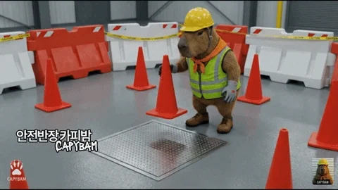 A gopher in high vis and a hard hat, putting some red cones around down on the ground. 