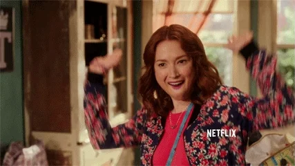 A woman raises her hands up and down with excitement, celebrating joyfully.
