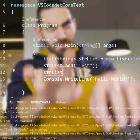 A man with a strained expression is typing on a keyboard, blurred in the background behind a screen displaying code snippets.