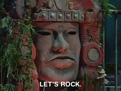 Olmec, the large stone head from Legends from the Hidden Temple, saying 'Let's rock.'